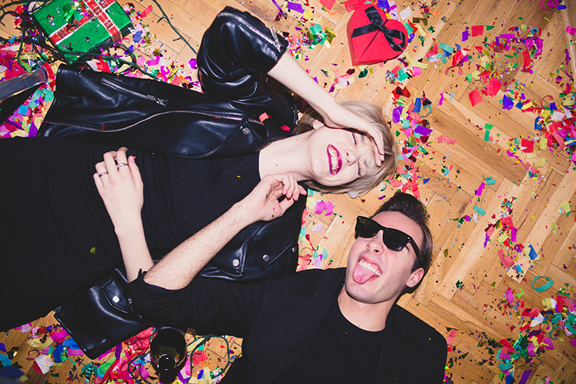 Party Girl And Boy Laying On The Floor Full Of Confetti